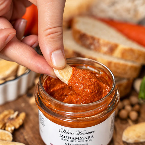 Detalle de la textura cremosa de la muhammara al mojar una tostada